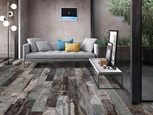 Rustic multi-tone plank tile laid through a living room with a concrete wall